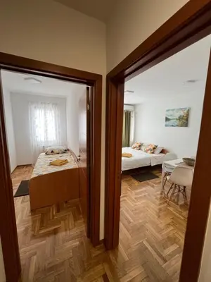 a bedroom with a bed and a room with a table at App Titan in Stara Pazova