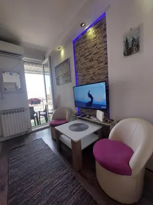 a living room with two chairs and a tv at Belgrade Waterfront studio in Sajmište