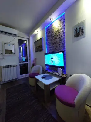 a living room with a computer monitor and two chairs at Belgrade Waterfront studio in Sajmište