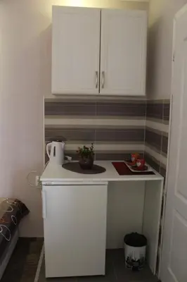 a small kitchen with white cabinets and a table at Belgrade Waterfront studio in Sajmište