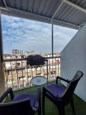 a balcony with two chairs and a table and a window at Belgrade Waterfront studio in Sajmište