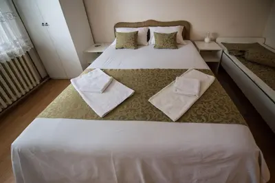 a bedroom with a large white bed with towels on it at Apartmani Pavlov in Arandjelovac