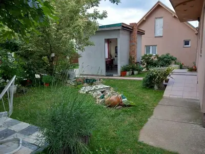 a house with a yard with a fire hydrant in the grass at Apartmani Pavlov in Arandjelovac