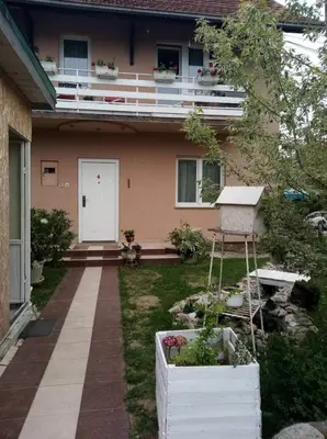 a house with a balcony and a yard with plants at Apartmani Pavlov in Arandjelovac