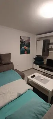 a living room with two beds and a flat screen tv at Stan na dan-MARKOVIĆ- in Dušanovac (historical)