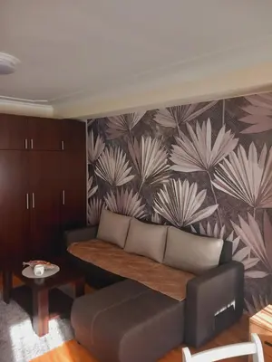 a living room with a couch and a wall with flowers at LIBERO 78 in Vračar (historical)