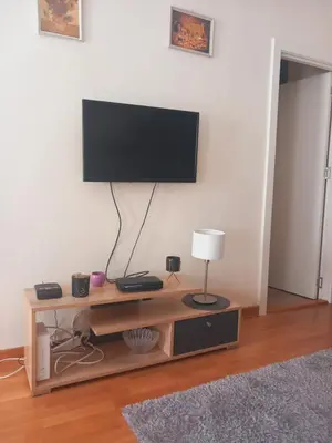 a flat screen tv sitting on top of a wooden entertainment center at LIBERO 78 in Vračar (historical)