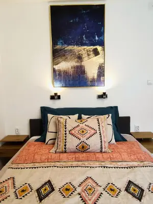 a bed with pillows and a painting on the wall at Penthouse Palace in Belgrade