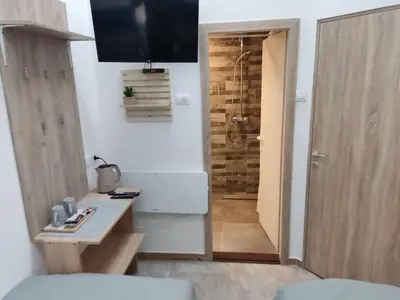 a bathroom with a shower and a television on the wall at Romansa in Dušanovac (historical)