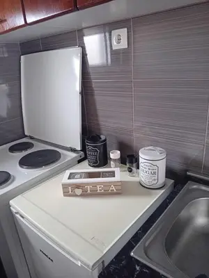 a small kitchen with a stove and a refrigerator at Apartman M Batajnica in Batajnica