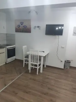 a kitchen with a white table and chairs in a room at Apartman M Batajnica in Batajnica