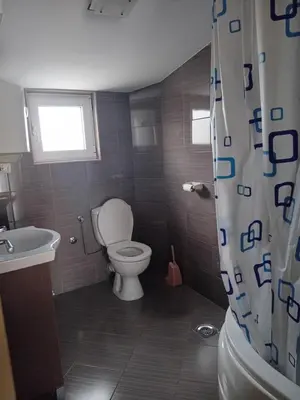 a bathroom with a toilet and a sink and a window at Apartman M Batajnica in Batajnica