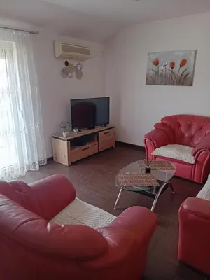 a living room with red furniture and a flat screen tv at Apartman M Batajnica in Batajnica