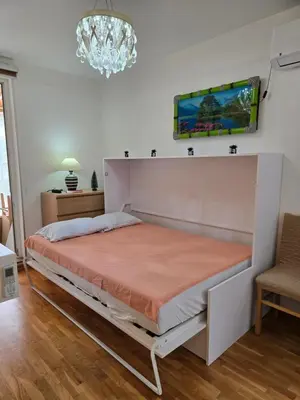 a large bed in a room with a chandelier at Laki 15 in Kalugjerica