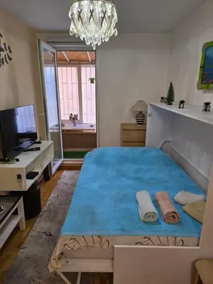 a bedroom with a large blue bed with towels on it at Laki 15 in Kalugjerica