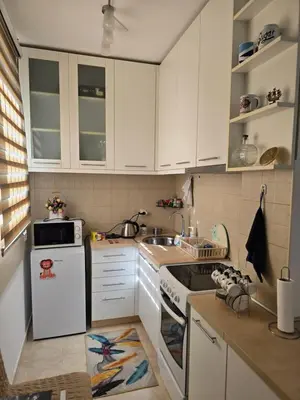 a kitchen with white cabinets and a white refrigerator at Laki 15 in Kalugjerica