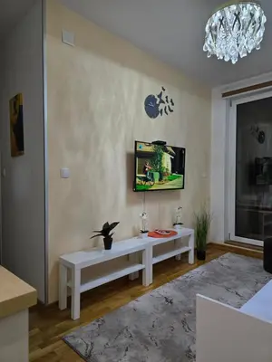 a living room with a white table and a tv at Laki 15 in Kalugjerica