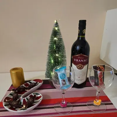 a bottle of wine and two glasses and a christmas tree at Laki 15 in Kalugjerica