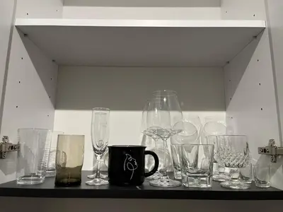 a bunch of glasses sitting on a shelf at Apartman Stevan in Pančevo