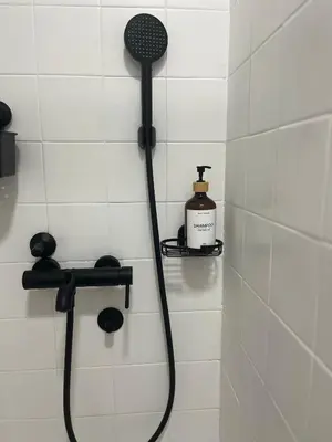 a shower with a shower head and a bottle of soap at Apartman Stevan in Pančevo