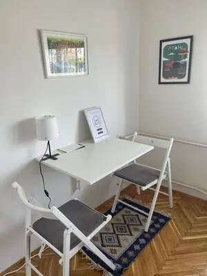 a white desk with two chairs and a lamp at Apartman Stevan in Pančevo