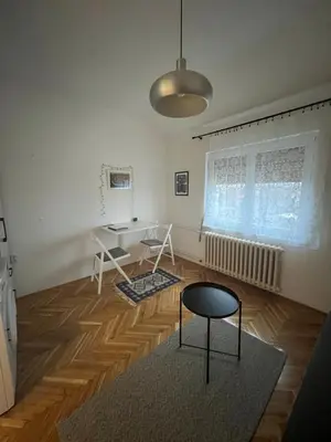 a living room with a table and a chair at Apartman Stevan in Pančevo