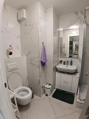 a bathroom with a toilet and a shower and a sink at Viva apartment in condominium in Voždovac