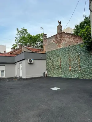 a brick wall next to a building with a parking lot at Paradiso1 in Vračar (historical)