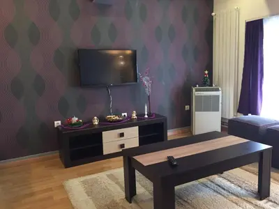 a living room with a tv and a coffee table at Kona Apartment in Belgrade