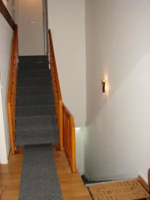 a hallway with a staircase with wooden railings at Kona Apartment in Belgrade