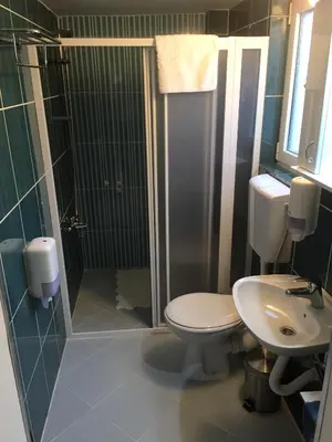 a bathroom with a toilet and a shower and a sink at Kona Apartment in Belgrade