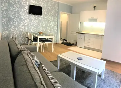 a living room with a couch and a table and a kitchen at Kona Apartment in Belgrade