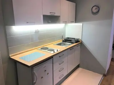 a small kitchen with a sink and a stove at Kona Apartment in Belgrade