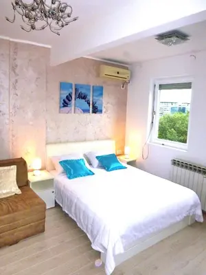 a bedroom with a large white bed and a window at Arena Dream Studio in Belgrade