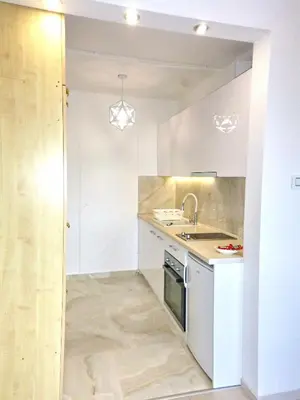 a kitchen with white cabinets and a sink at Arena Dream Studio in Belgrade