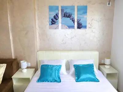 a bedroom with a white bed with blue pillows at Arena Dream Studio in Belgrade