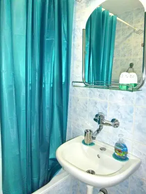 a bathroom with a sink and a blue shower curtain at Arena Dream Studio in Belgrade