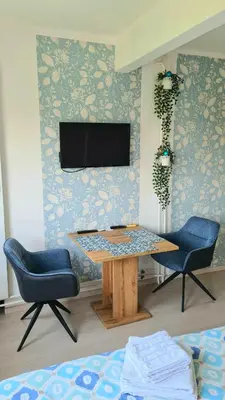 a living room with a table and two chairs and a television at Arena Dream Studio in Belgrade