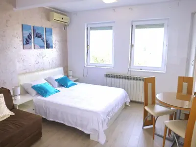 a bedroom with a bed and a table and a couch at Arena Dream Studio in Belgrade