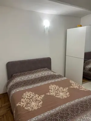 a bedroom with a bed and a white refrigerator at Rio Apartman in Belgrade
