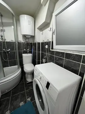 a bathroom with a washing machine and a toilet at Rio Apartman in Belgrade