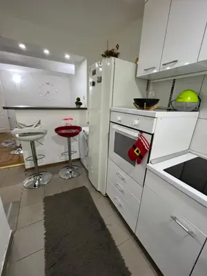 a kitchen with a white refrigerator and a stool at Rio Apartman in Belgrade