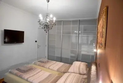 a room with a bed with a chandelier in it at Angel Apartment in Belgrade