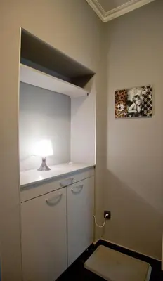 a small room with a white cabinet and a lamp at Angel Apartment in Belgrade
