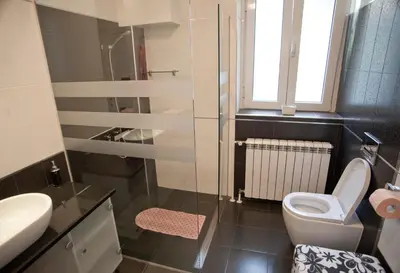 a bathroom with a toilet and a glass shower at Angel Apartment in Belgrade