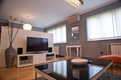 a living room with a tv and a table at Angel Apartment in Belgrade