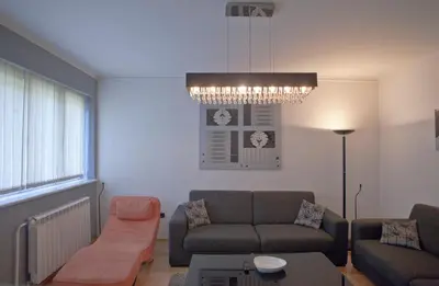 a living room with a couch and a chandelier at Angel Apartment in Belgrade