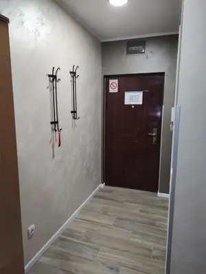 a hallway with a door and some ski equipment on the wall at Left Coast studio apartment in Belgrade