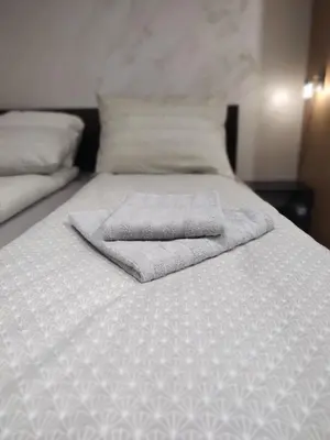 a bed with two towels on top of it at Left Coast studio apartment in Belgrade