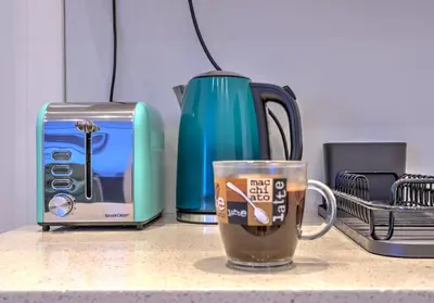 a cup of coffee sitting next to a toaster and a toaster at Belgrade City Center Modern Apartment in Belgrade